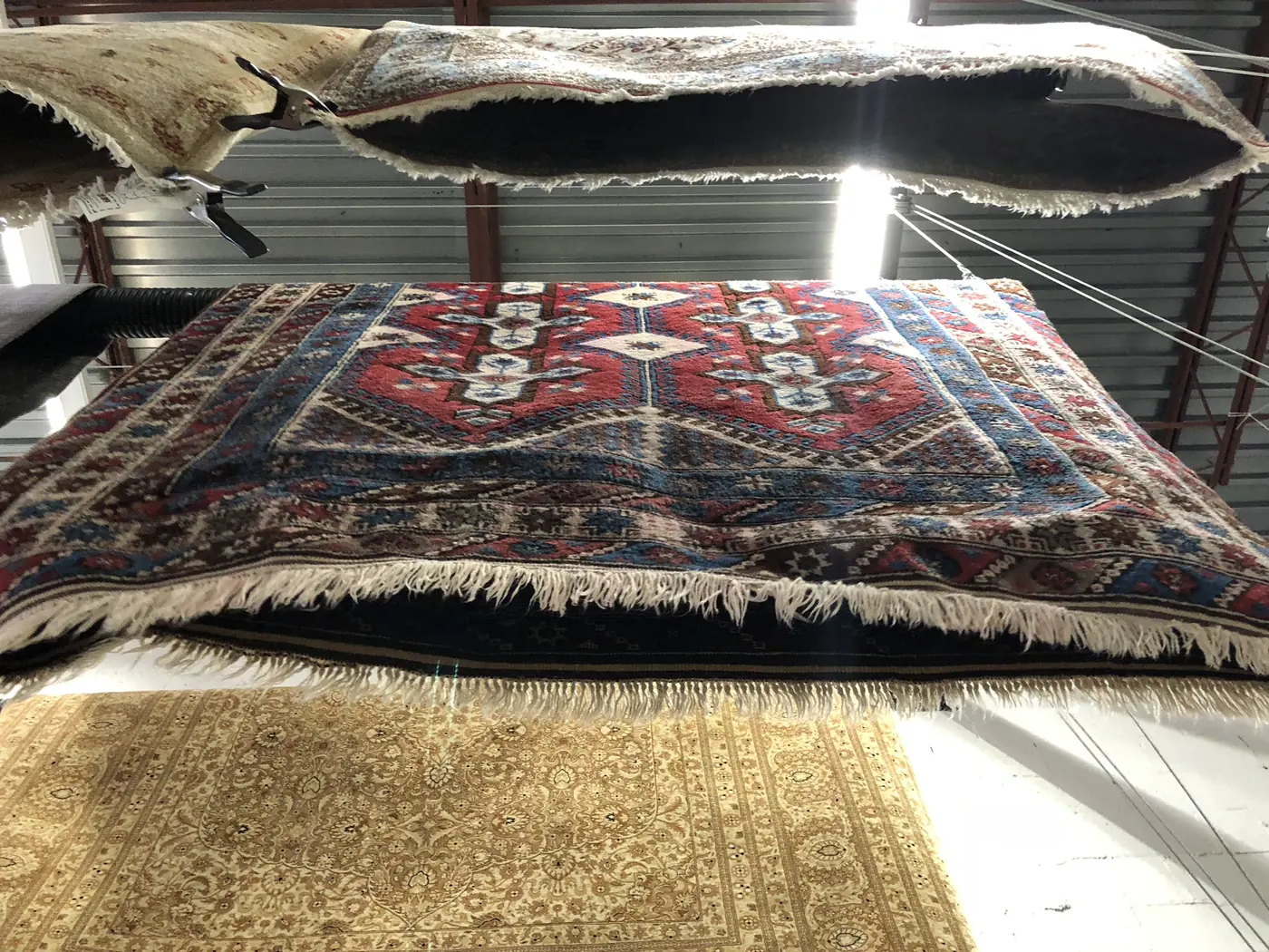 A stack of colorful cleaned rugs waiting to be delivered